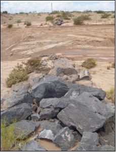 En la fotografía de la derecha se observa: adelante defensa de piedras que fuera arrastrada por la crecida; atrás movimiento de suelos contaminados.
